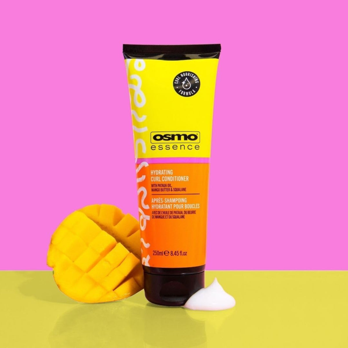 Osmo Essence Hydrating Curl Conditioner tube i gul og orange med udskåret mango på lyserød baggrund.