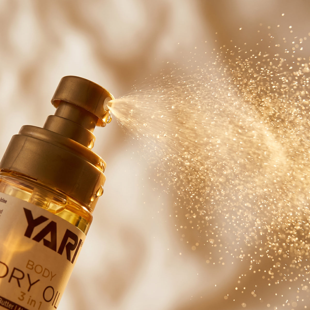 Yari Body Dry Oil 3 in 1 i gylden flaske, der sprayer fin tåge af kropsolie.